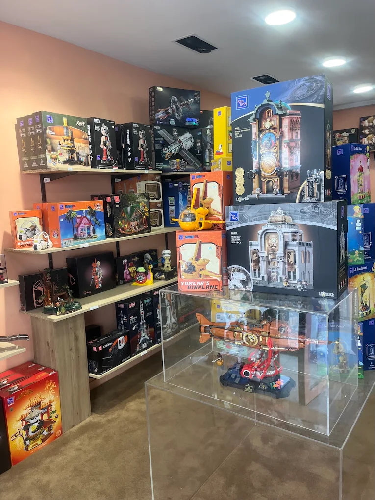 Intérieur de la boutique : murs saumons et étagères remplies de sets